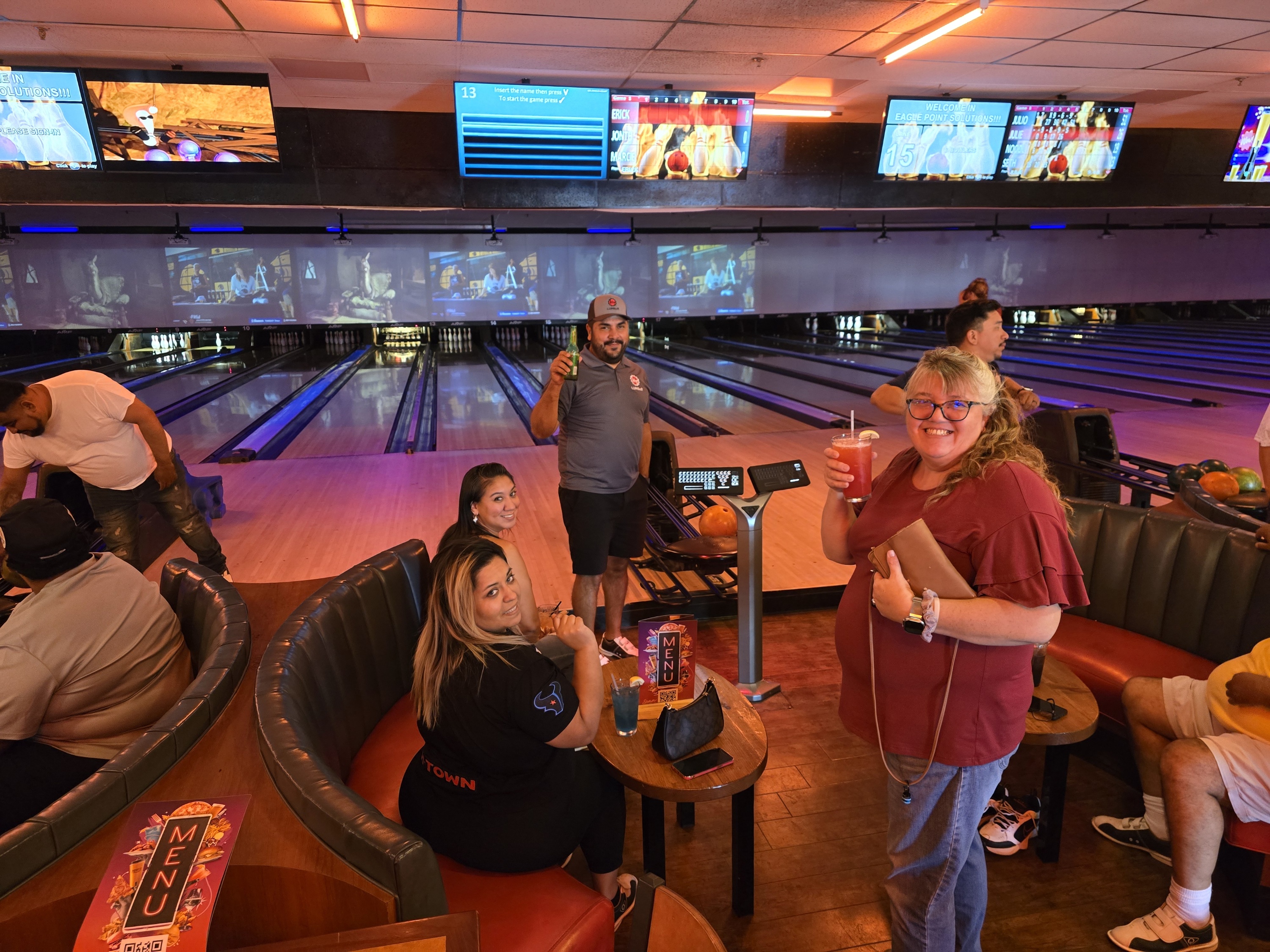 People enjoy drinks at a bowling alley lounge.